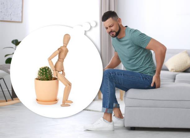 Image of a man sitting on a couch with pain in his stomach